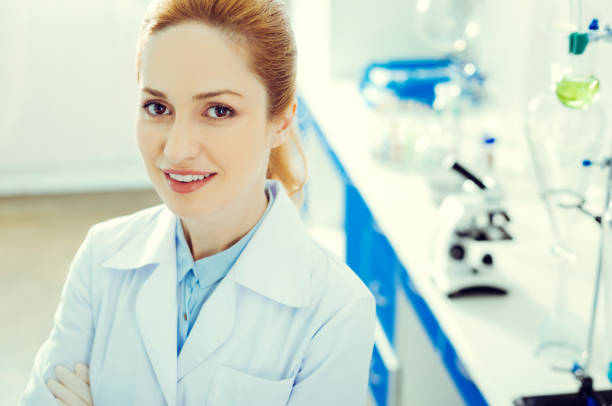 istock Cheerful adult woman smiling while looking into camera in laboratory 936858062