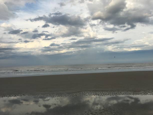 istock Cloudy sky reflected on the sand at New Smyrna Beach 936861544