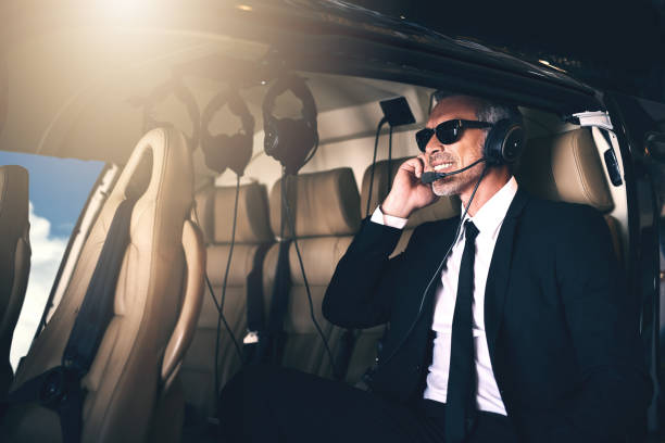 Are we ready for take off? Shot of a mature businessman using a headset while traveling in a helicopter military private stock pictures, royalty-free photos & images