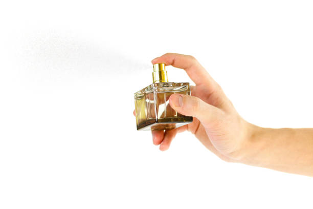 istock The hand holding the Cologne. Sprays perfume. Isolated on a white background. Close up 936862026