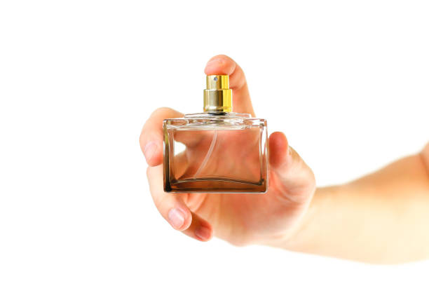 istock The hand holding the Cologne. Sprays perfume. Isolated on a white background. Close up 936862038