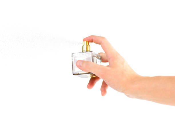 a mão segurando a colónia. sprays de perfume. isolado em um fundo branco. close-up - 4727 - fotografias e filmes do acervo