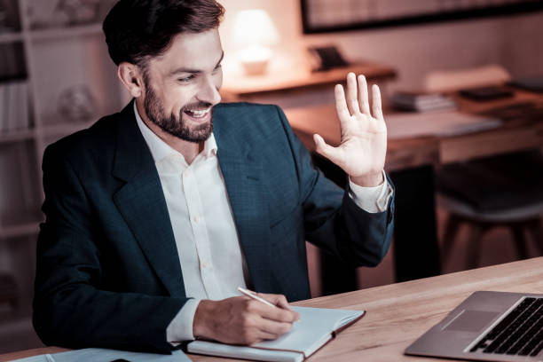istock Satisfied occupied man having video conversation and writing 936862644