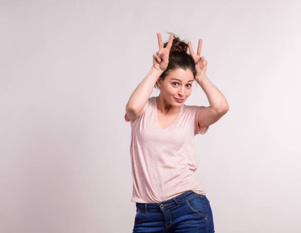 istock Young beautiful woman in studio making bunny ears. 936867650