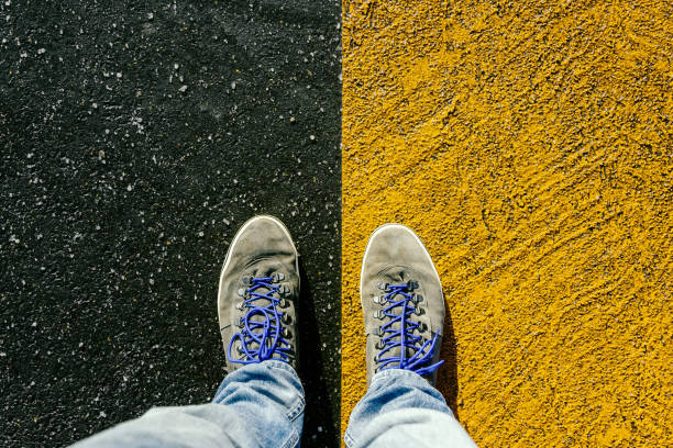 istock Concept of facing a crucial decision shown by shoes on different colored pathways 936867760
