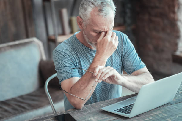 istock Exhausted senior man sitting and having head ache 936876780