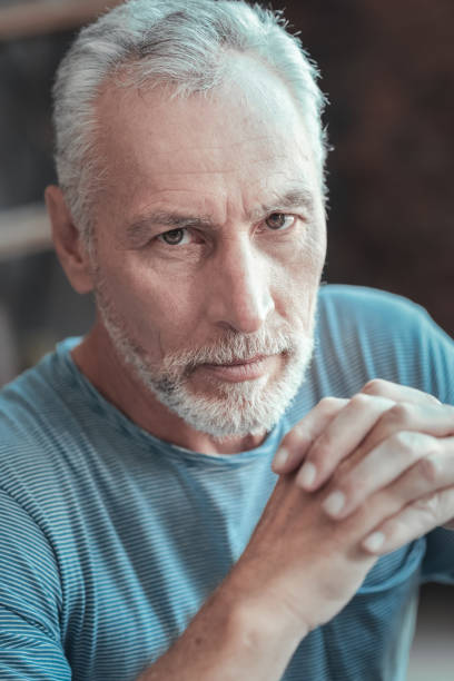 istock Concentrated serious man holding hands together and looking straight 936877036