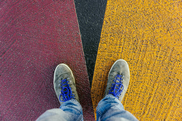istock Concept of facing a crucial decision shown by shoes on different colored pathways 936882412