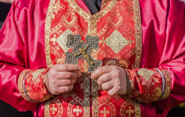 Orthodox priest holding ritual crest.