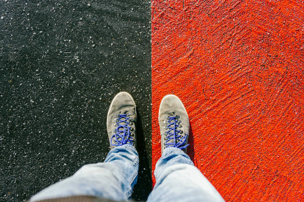 istock Concept of facing a crucial decision shown by shoes on different colored pathways 936882652
