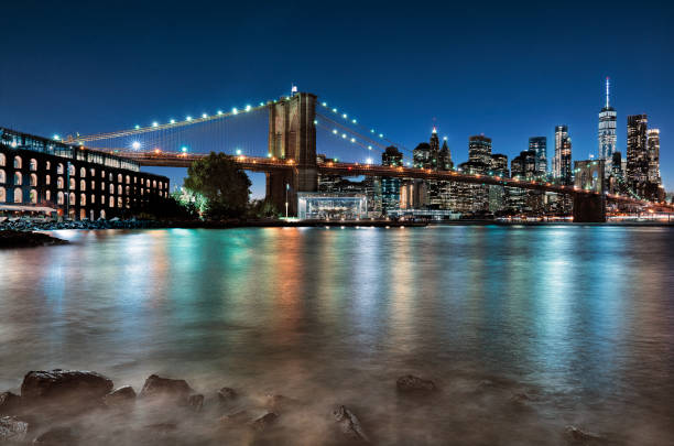 New York city view with Brooklyn bridge A famous view of Brooklyn bridge and Manhattan. new york city skyline new york state night stock pictures, royalty-free photos & images