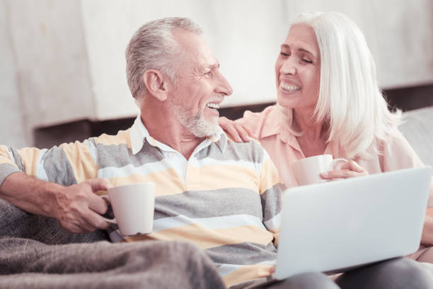 istock Happy aged couple laughing and drinking tea 936886240