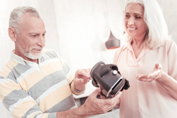 istock Gaged interested man standing and holding VR glasses 936886348