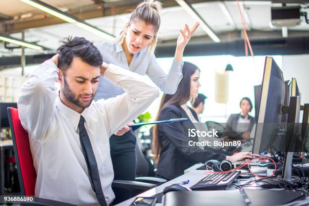 Angry Businesswoman Shouting At Her Worker With Hands Behind Head In Office Stock Photo - Download Image Now