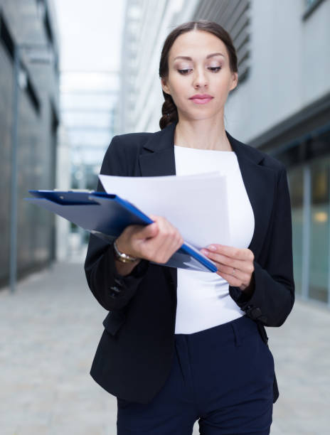 directora creativa está examinando documentos - success signing businesswoman serious fotografías e imágenes de stock