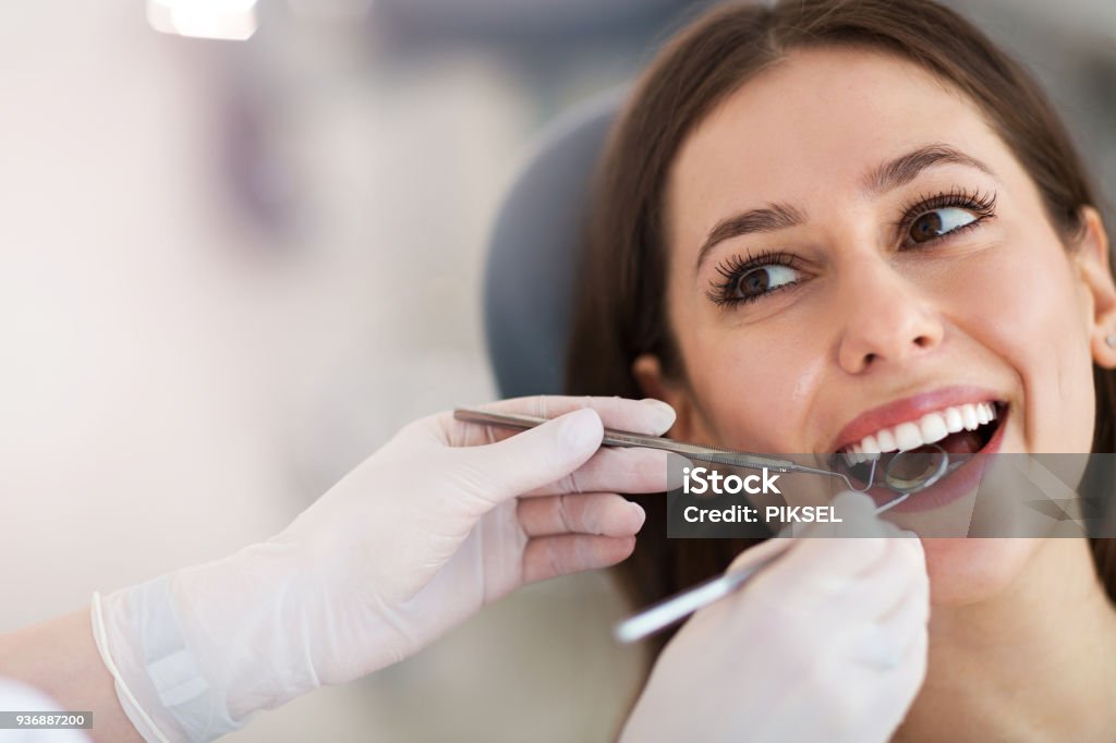 Donna con i denti esaminati dai dentisti - Foto stock royalty-free di Dentista