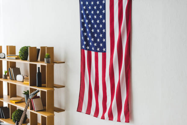 american flag hanging on wall inside living room - house home interior flag usa imagens e fotografias de stock