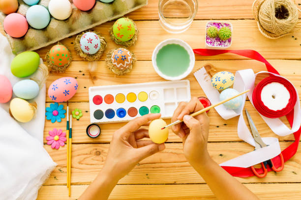 istock Happy easter! A woman hand painting Easter eggs. Happy family preparing for Easter. 936889446