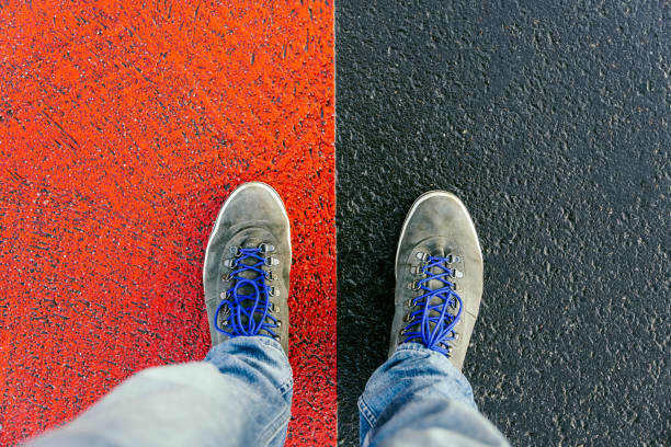 istock Concept of facing a crucial decision shown by shoes on different colored pathways 936890610