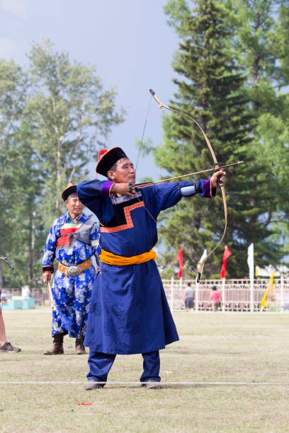 istock Young man shoots from a sports bow 936891372