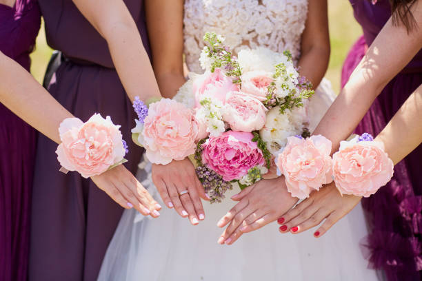 istock Hands of the bride and girlfriend with decorative flowers 936891404