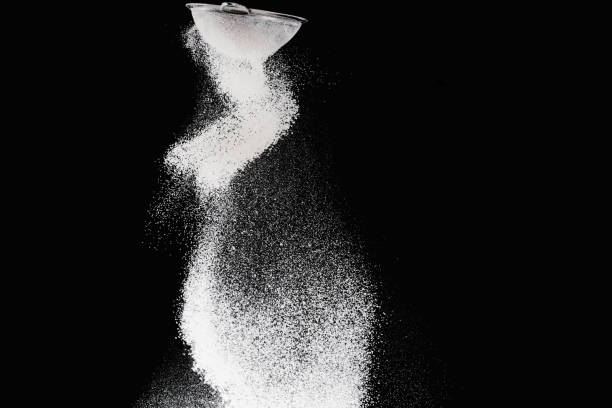 istock sieve with falling flour isolated on black 936893656