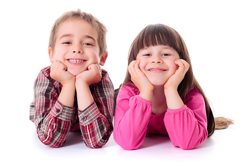 three little girls sitting on a bench smiling and sticking tongue out