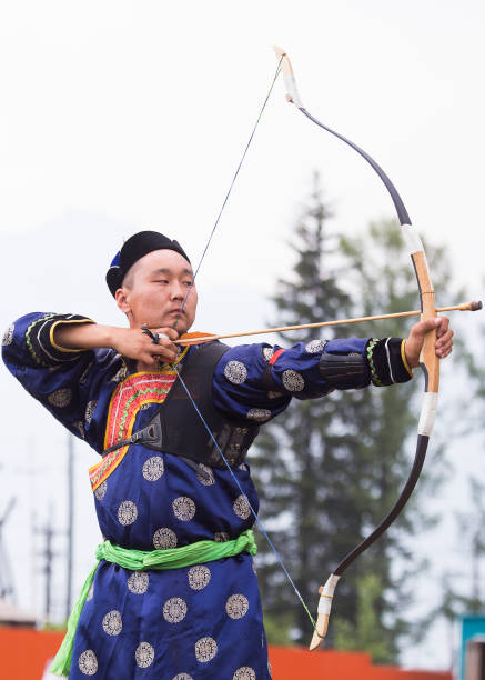 istock Young man shoots from a sports bow 936893788