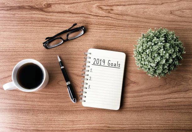 2019 New Year's Goals New year goals and resolution concept - 2019 goals text on notepad. Retro style background. 2019 new year resolution stock pictures, royalty-free photos & images