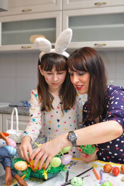 istock Mom and girl smiling and play with Easter eggs and paint 936894266