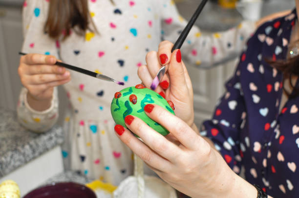 istock Mother and daughter painting Easter eggs 936894750