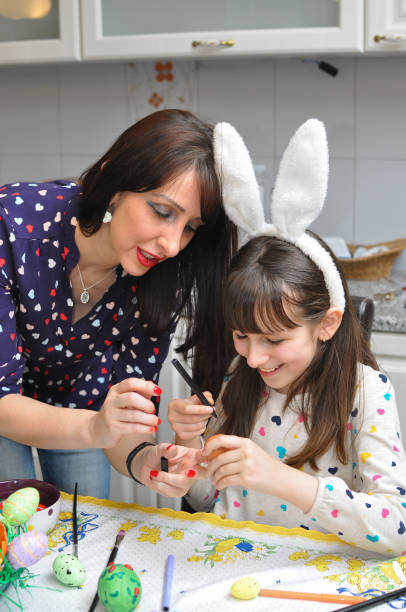 istock Mother and daughter painting Easter eggs 936894834