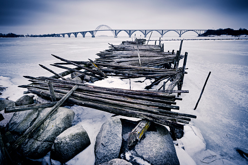 Atmospheric shot of the frozen harbour at Kalvehave in south Zealand on a very cold morning during the winter storms of March 2018. In the background is the Queen Alexandrine’s Bridge to the island of Moen. Colour, horizontal with some copy space.