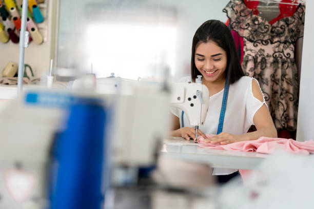 istock Happy seamstress sewing at an aterlier with a machine 936901656
