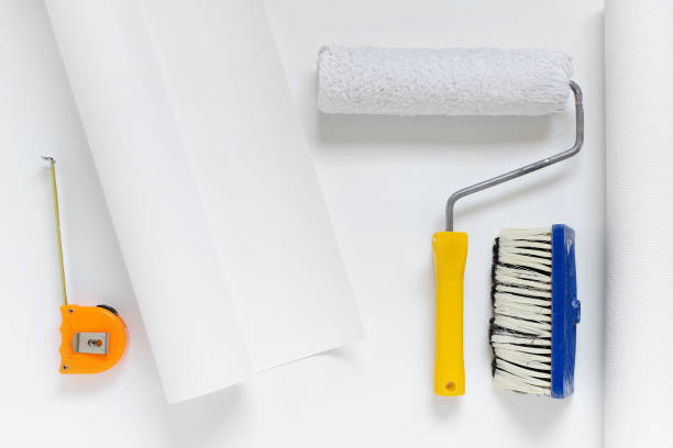 istock white wallpaper roll with paint roller, brush, tape measure 936902608
