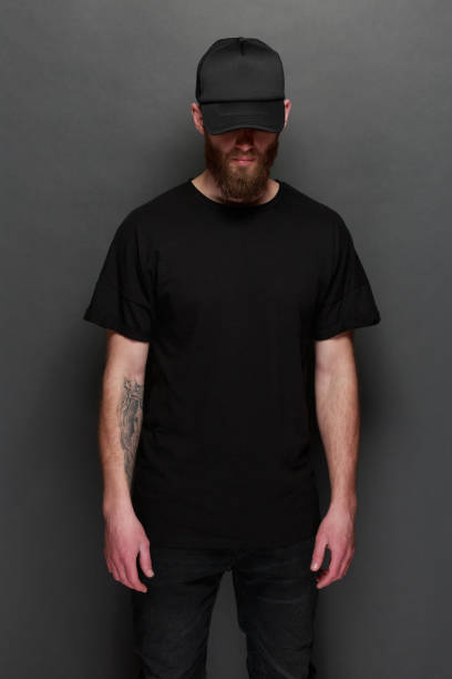 хипстер красивый мужчина модель с бородой носить �черную пустую футболку и черную бейсболку с пространством для вашего логотипа или дизайн� - black cap стоковые фото и изображения