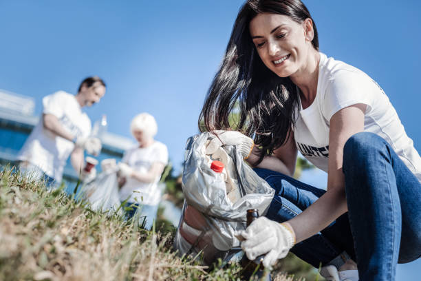 joyful nice woman collecting glass bottles - wasting time imagens e fotografias de stock