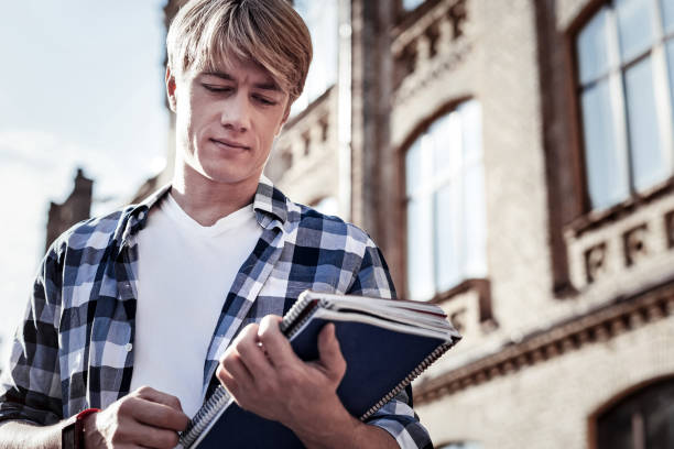 istock Nice serious man looking at his books 936920438