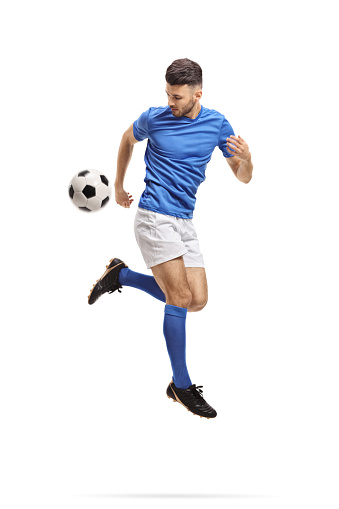 Soccer player performing a trick with a football in mid-air isolated on white background