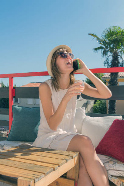 istock Cute girl using cellphone and drinking white wine. 936923832