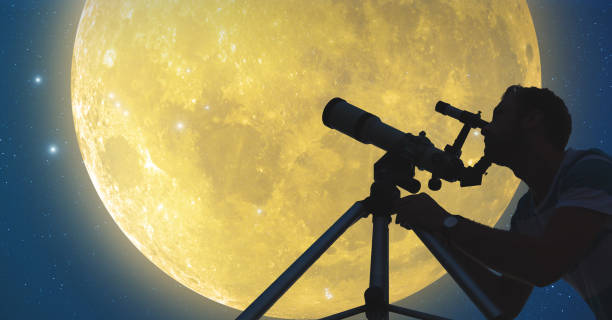 hombre con un telescopio mirando la luna y las estrellas. - super moon fotografías e imágenes de stock