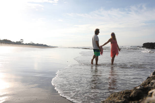istock Couple walk in shallows in morning light 936924646