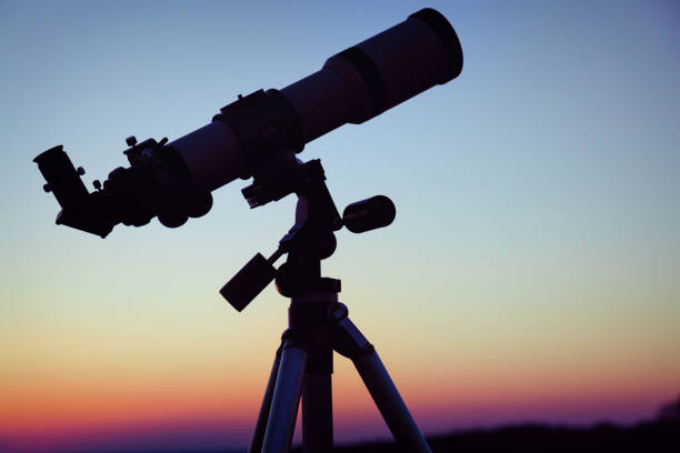 istock Silhouette of a telescope with evening sky in the background. 936925736