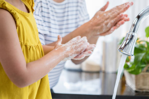 お母さんが娘の手を洗浄する方法適切なを示しています - rubbing human hand togetherness women ストックフォトと画像