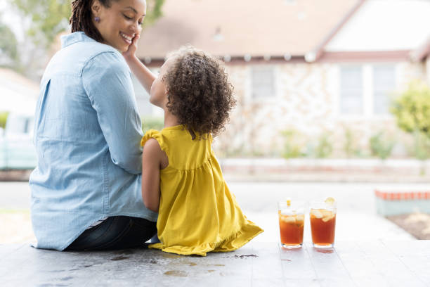 istock Mom and daughter relax on front porch 936928022