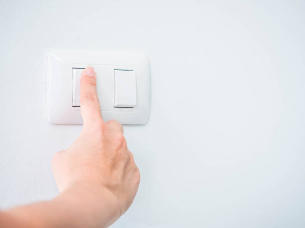 istock Woman is pressing the switch button for turning off the light. 936933640