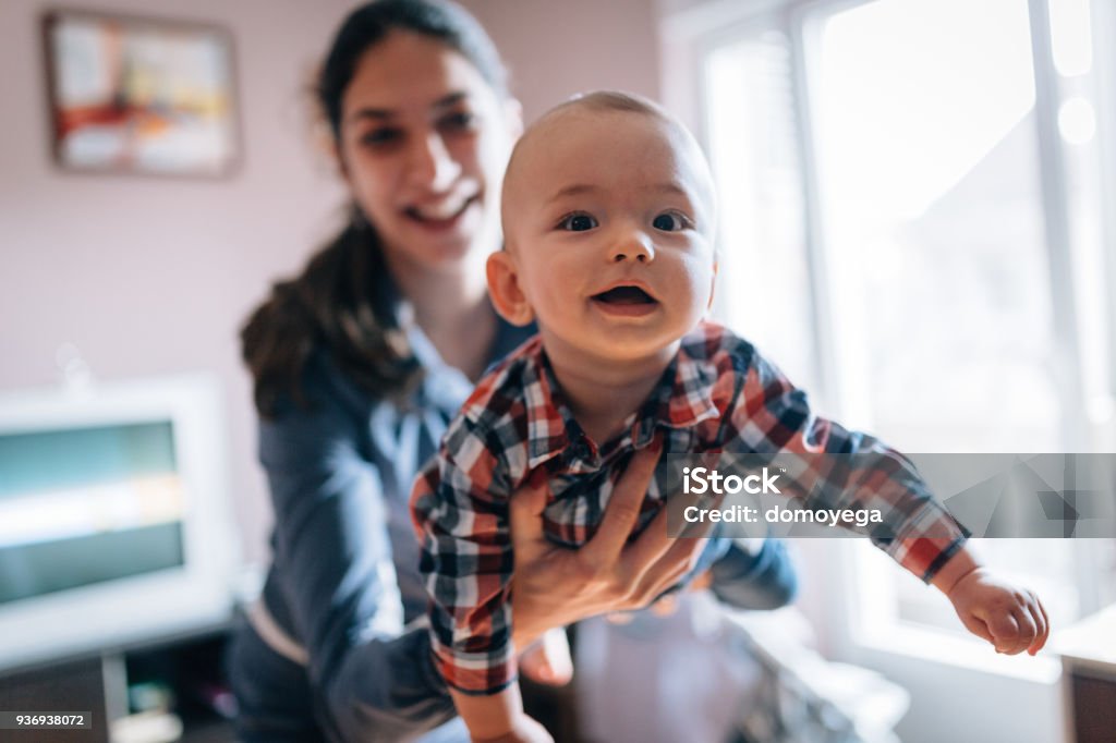 Mother holding cute baby at home Mother Stock Photo