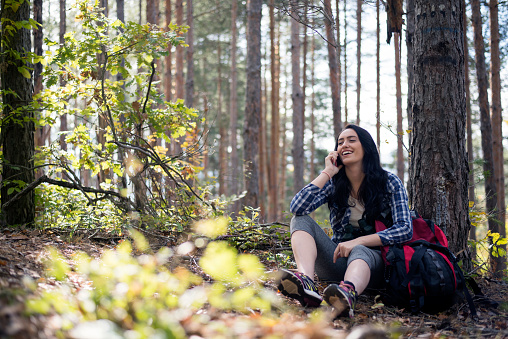 Young woman using a smartphone in the forest