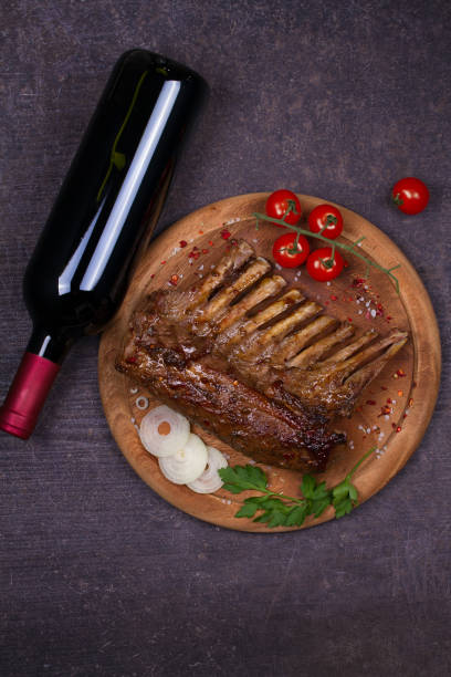 vin rouge et la viande. grillé de carré d’agneau au vinaigre balsamique et sauce au sucre brun, verre et bouteille de vin. côtelettes d’agneau aux légumes - balsamic vinegar bottle vinegar red wine photos et images de collection