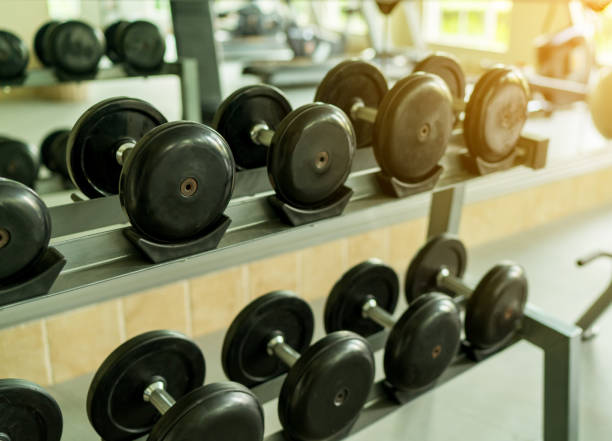 istock dumbbell gym on the training room, flare light. 936939528